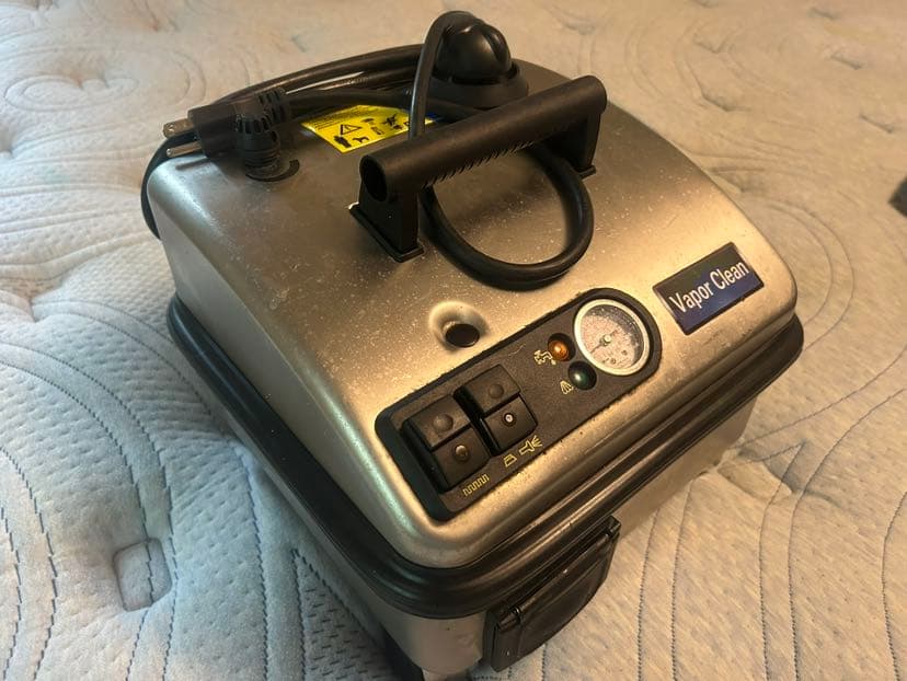 Dry vapor steam cleaner applied to the surface of a mattress